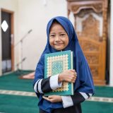 muslim girl kid holding quran at the mosque